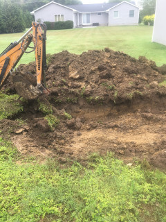 Hole dug to bury clay and rock