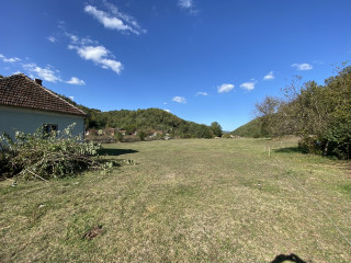 About 2.5 acres of flat land at the back, along a creek to the left, and woods on the rear right.