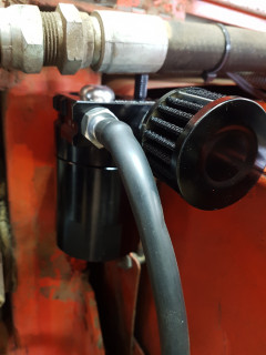 remote filter housing mounted on the loader frame near the fire wall .