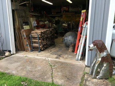 Toby the metal dog looking over wood supply.