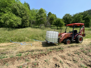 Using this 1000 litres container that I fill up at the creek next to the house. I attached a hose with a valve on to the container.