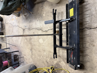 Front view of dethacher, has rod to lift unit and foot pedal to hold so hands are free to steer